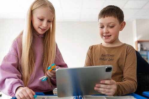 Eine Schülerin und ein Schüler mit einem iPad