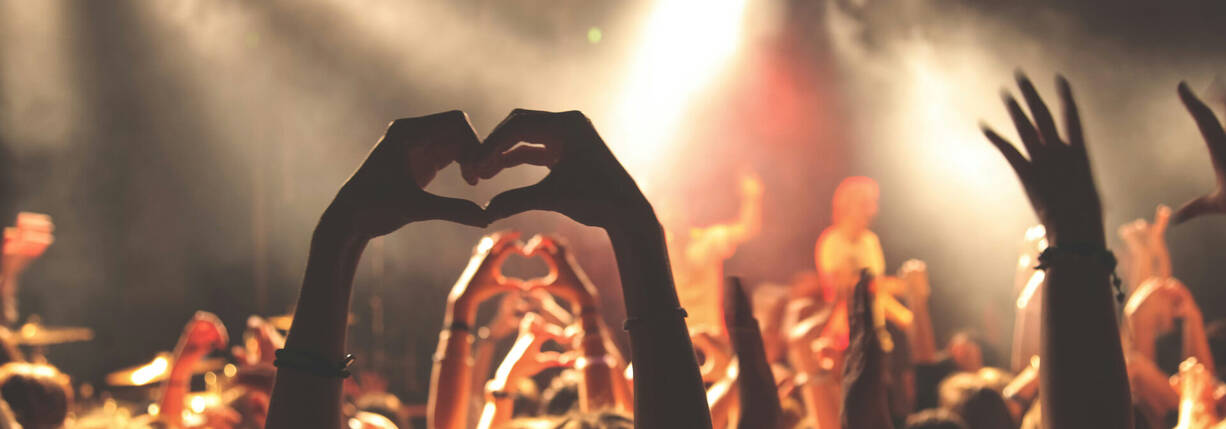 Zwei Hände formen Herz an Konzert