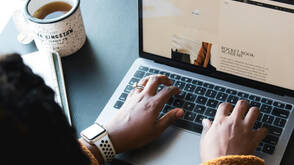 Zwei Frauenhände schreiben auf MacBook