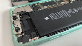iPhone mit geöffneter Hülle und sichtbarem Akku