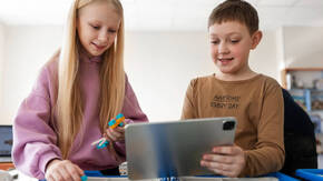 Zwei Lernende mit iPad in der Schule