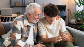 Ein älterer Mann und ein junger Mann mit iPhone