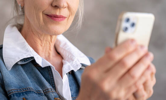 ältere Frau hält ihr iPhone vors Gesicht