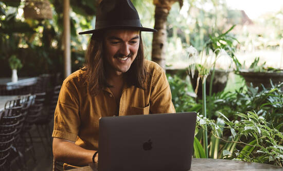 Mann mit MacBook in Café