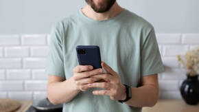 Mann schaut in sein iPhone