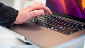 Hand auf MacBook Tastatur