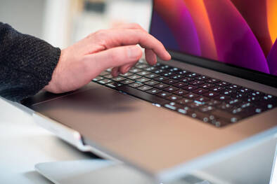Hand auf MacBook Tastatur