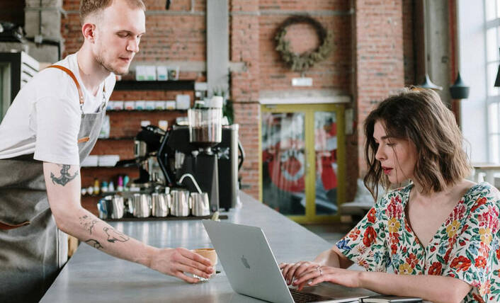 Sicherheit ist wichtig in fremden Netzwerken. (Foto: Cottonbro / pexels) Frau mit Mac in einem Café