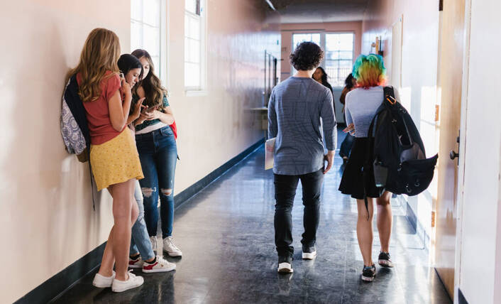 Teenager nutzen iPhone täglich (Foto: RDNE / pexels) Teenager mit iPhone im Schulhausgang