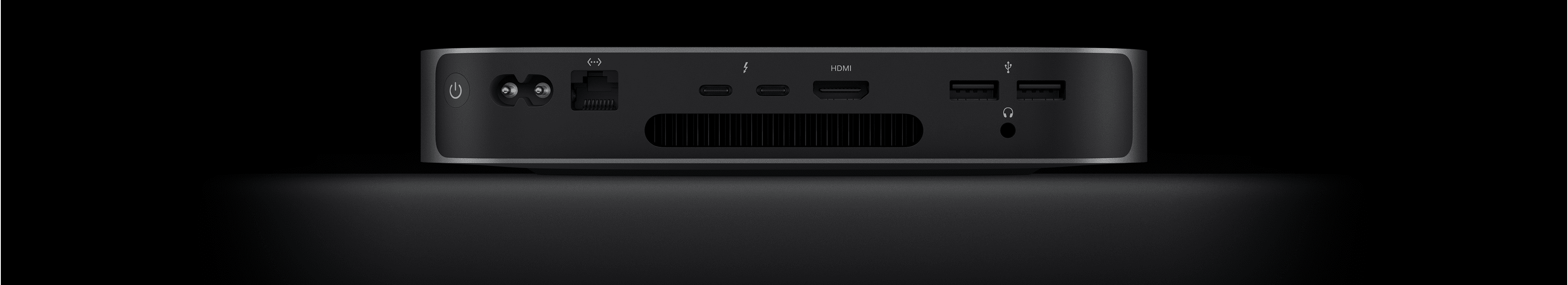 Rückansicht des Mac mini, die die zwei Thunderbolt 4 Anschlüsse, den HDMI Anschluss, zwei USB‑A Anschlüsse, den Kopfhöreranschluss, den Gigabit Ethernet Anschluss, den Netzeingang und den Ein‑/Ausschalter zeigt.