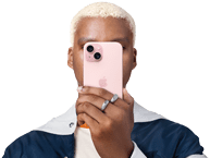 Eine Person hält sich ein iPhone 15 vors Gesicht, um ihre Identität zu verbergen