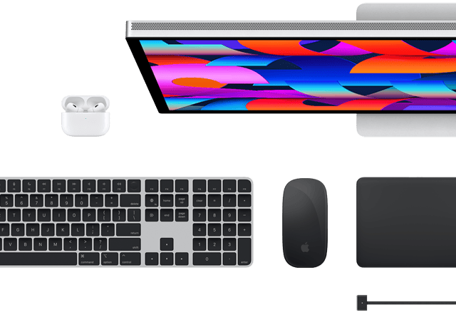 Accessoires Mac vus d’en haut : Studio Display, Magic Keyboard, Magic Mouse, Magic Trackpad, AirPods et câble de charge MagSafe